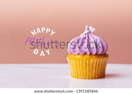 Happy Mothers Day, cute cupcake with small white heart on purple cream on pink background