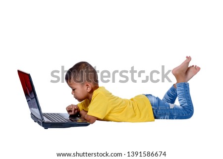 Cute little Asian girl child lying on the floor studying or using laptop isolated on white background with clipping path. Kids and education concept