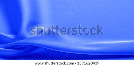 background texture, pattern. blue silk fabric. This lightweight fabric has a brilliant shine that perfectly reflects the light and crumpled texture that adds interest and depth to any fabric design.