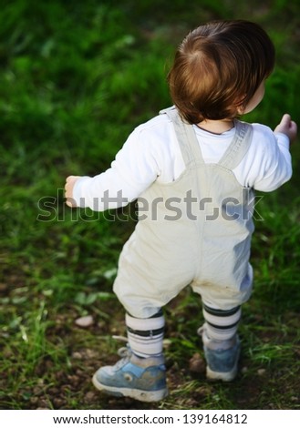 Baby kid walking on the green grass