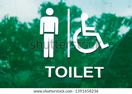 Creative toilet  & restroom sign with reflection of tropical summer green tree & leaf in park, environment friendly & ecology concept. Man and  disabled restroom signage with white silhouette people