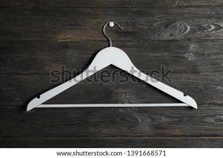 Empty clothes hanger on wooden wall. Wardrobe accessory