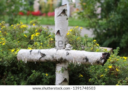 The cross on the grave in the cemetery.