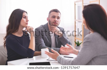 Expert advice. Thoughtful young couple listening to confident financial advisor explaining something important