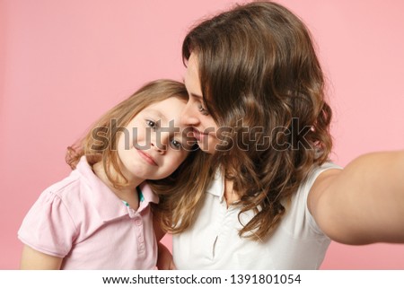 Close up selfie shot woman in light clothes have fun with cute child baby girl. Mother, little kid daughter isolated on pastel pink wall background, studio portrait. Mother's Day, love family concept