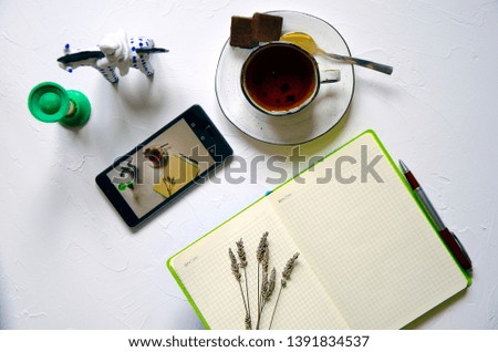 Workspace with notepad, cup of tea on a white background. Flat lay, top view office desk writing desk. Workplace freelancer. Copyspace.