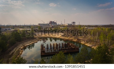Aerial shot of an artificial lake with old metallic rods in Chernobyl zone in spring