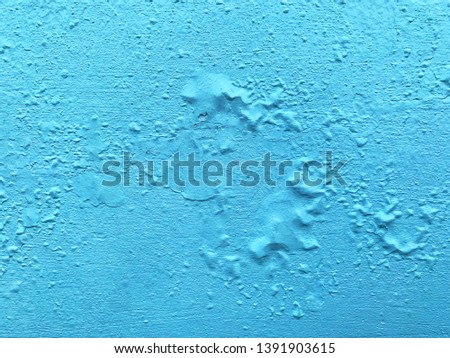 The blue color on the cement wall is peeling, sifted color sheet, and bulging knot because of the moisture from the rain
