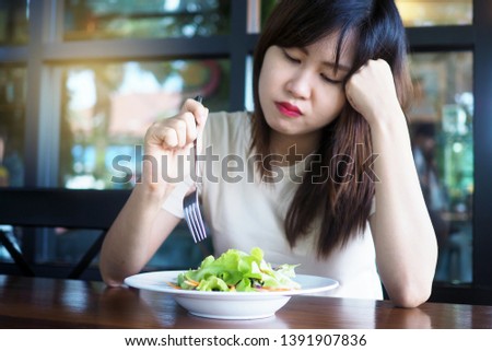 Women look at vegetable salads bored when it's time to lose weight. Patient to eat vegetables       Royalty-Free Stock Photo #1391907836
