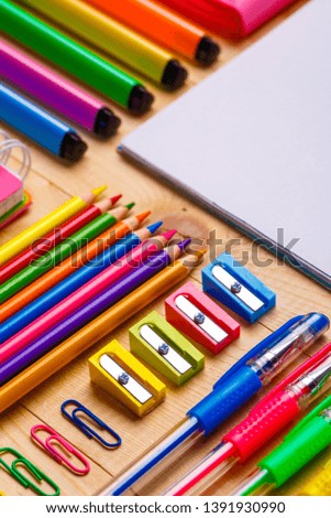 Stationery accessories are spread out on a wooden background. Colorful Back to School background. flat lay