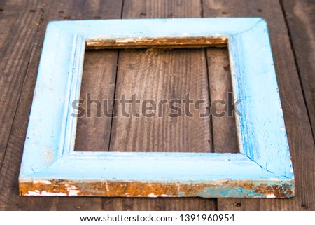 Wooden frame for a photo on the background of a wooden surface. Country style
