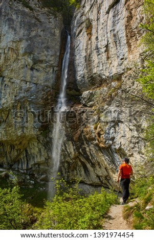 Professional nature photographer shooting a waterfall in the mountains