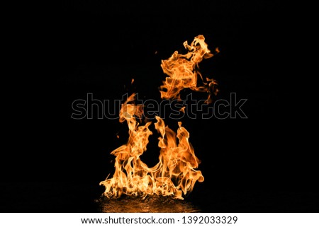 Flames with water reflections on a black background.