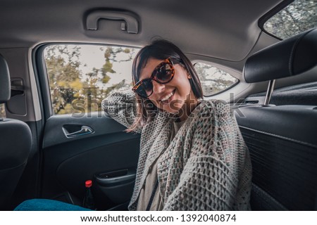 Portrait of beautiful smiling happy woman in back of a car