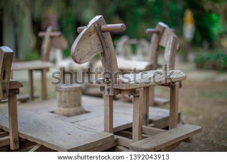 The background of a blurred wooden chair (shaped like a horse) is a sitting spot for children or for tourists to take pictures on the go, a new design that is of interest to customers in modern times.