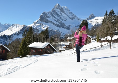 Girl with a camera in Swiss Alps