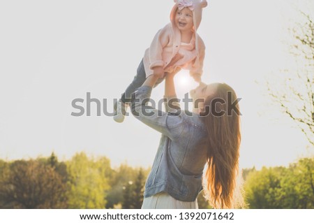 Outdoor Portrait of happy family. Beautiful happy mother and her daughter playing in nature in spring. Happy family. Happy Mother's Day. Motherhood, childhood.