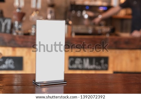 Mock up Menu frame standing on wood table in coffee shop. space for text.