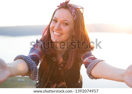 Smiling young woman takes a selfie in Mountains, blur