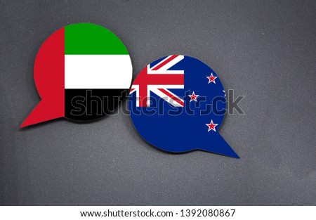 UAE and New Zealand flags with two speech bubbles on dark gray background