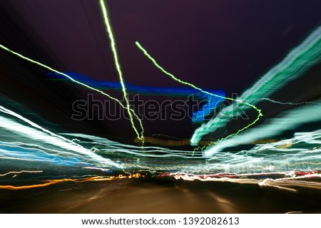 Abstract Background of Colorful bokeh with street lights at night,motion movement with traffic lighting in the city on car windshield view,blur background.Speed fast with driving car.Long exposure.