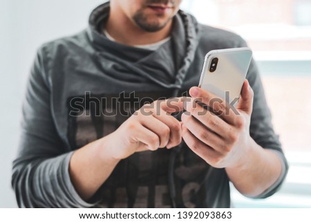 Man using modern smartphone in home interior