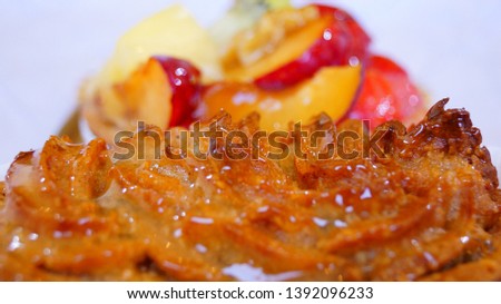 Fruit cake on top close up background. Lemon Shortbread. Bakery product on background of wrapping paper. Strawberry, walnut, plum, peach, kiwi, melon, pineapple filling. Pastel.
