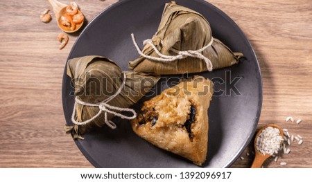 Zongzi, steamed rice dumplings on wooden table bamboo leaves, food in dragon boat festival duanwu concept, close up, copy space, top view, flat lay