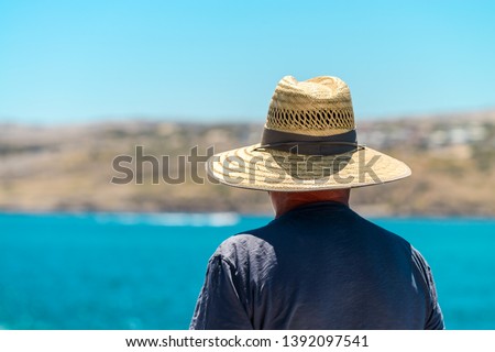Senior australian traveler with straw hat viewing  land from ship