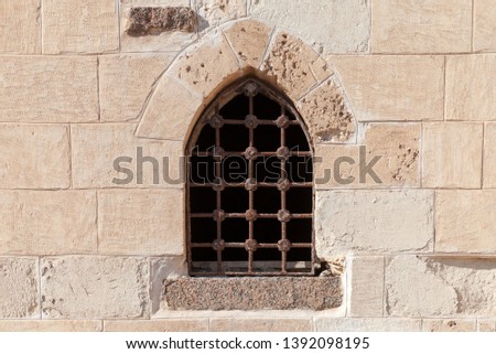 Old fortress stone wall with small window. Background photo texture 