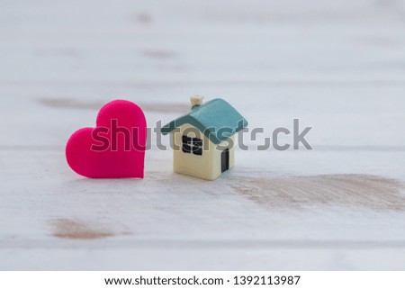 House with a red heart on white wooden background