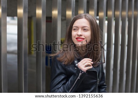 Fashioned girl in leather jacket in dark glasses 