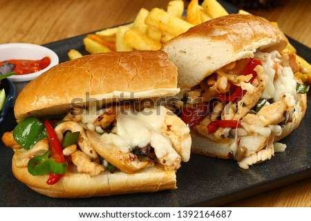 Submarine baguette chicken sandwich with melted cheese, vegetable and french fries Royalty-Free Stock Photo #1392164687