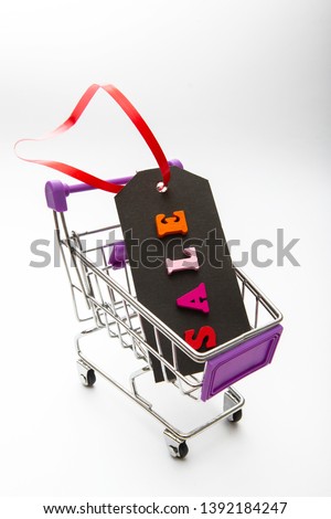 black tag with the words sale in Caddy for shopping. Cardboard label with the inscription sale on a white background. Holiday sales concept
