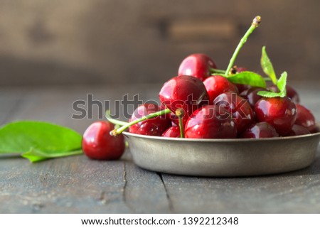 Merry or Cherries harvest in rural garden.  berries in bowl on wooden plank surface.