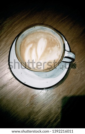 Art shape coffee mug on wooden tabletop retro colour contrasty photo from above