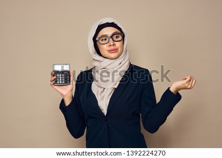 woman in hijab holding calculator                               