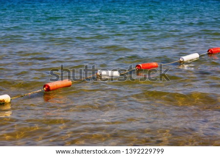 Fencing for swimming. Protective buoys on sea surface. Safety fencing on water.