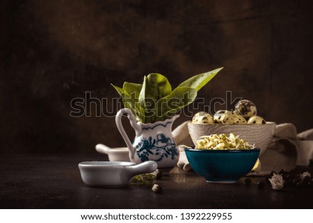 Horizontal photo of vintage wooden board with several bowls which contain mung bean sprouts, quail eggs and spinach. Light cloth is under one bowl.