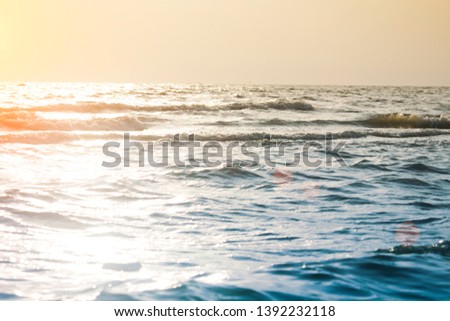 Sea waves at the beach in the evening along with the orange light of the sunset.Coastal view of Pattaya, Thailand