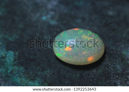 Opal cabochon on a copper background. Opal jewelry stone.