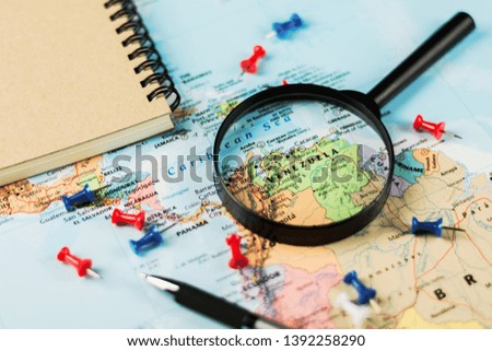 magnifying glass on the world map selective focus at venezuela. - economic crisis concept.