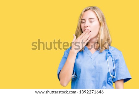 Beautiful young doctor woman wearing medical uniform over isolated background bored yawning tired covering mouth with hand. Restless and sleepiness.