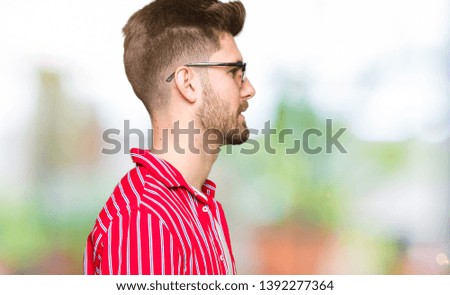 Young handsome man wearing sunglasses looking to side, relax profile pose with natural face with confident smile.