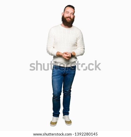 Young hipster man wearing winter sweater Hands together and fingers crossed smiling relaxed and cheerful. Success and optimistic