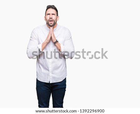 Young business man over isolated background begging and praying with hands together with hope expression on face very emotional and worried. Asking for forgiveness. Religion concept.
