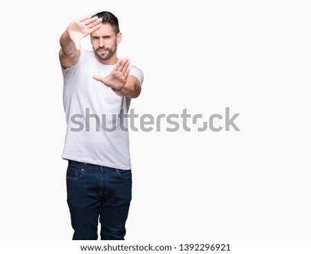 Handsome man wearing white t-shirt over white isolated background Smiling doing frame using hands palms and fingers, camera perspective