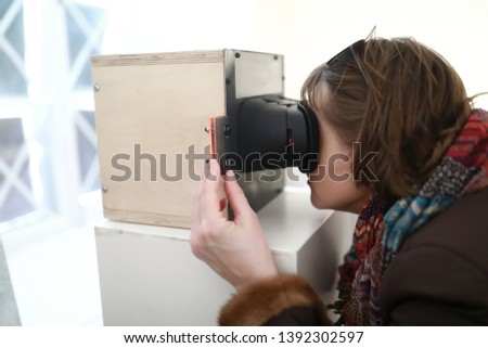 Woman watching slides in stereoscope in laboratory