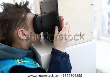 Boy watching slides in stereoscope in laboratory