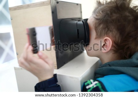 Child watching slides in stereoscope in laboratory